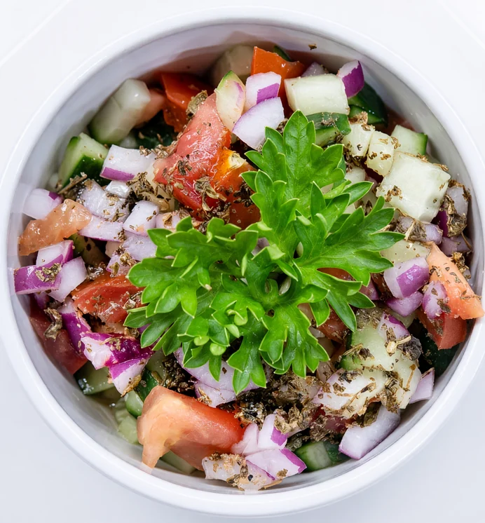 Shirazi salad of diced cucumber, tomato and red onion topped with fresh parsley in a white bowl at AFRA Grill, Saskatoon