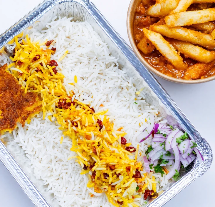 Gheymeh split-pea stew topped with fries in a bowl beside a foil tray of white and saffron rice at AFRA Grill, Saskatoon