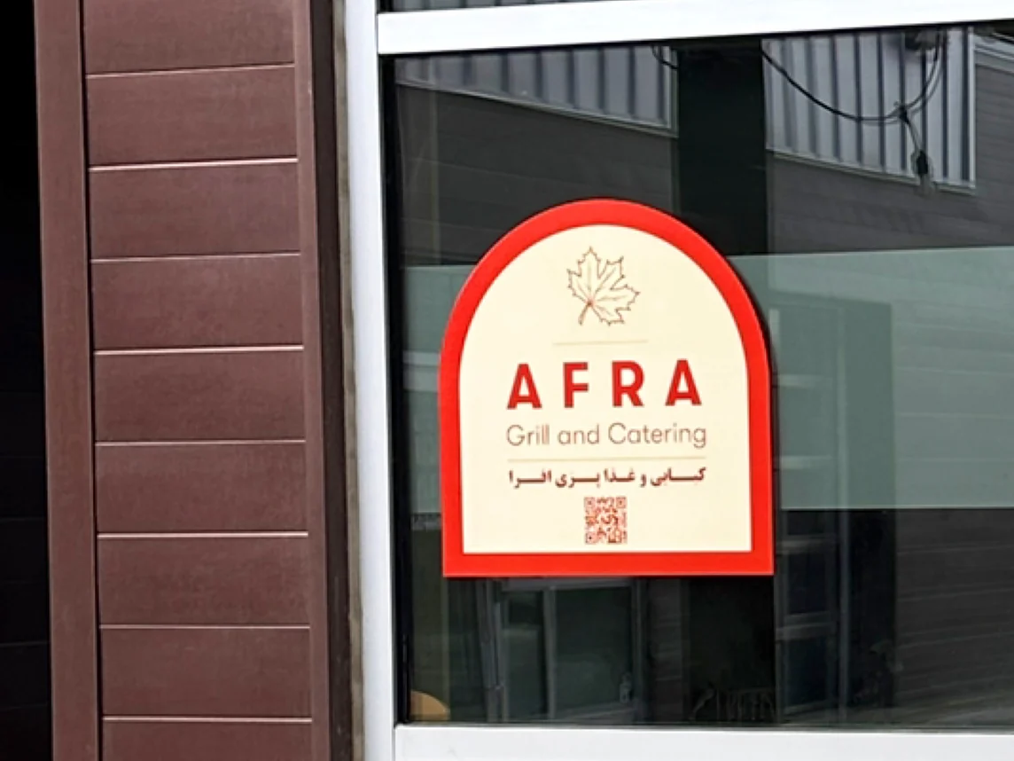 AFRA Grill and Catering sign in the front window at 123 Avenue B South, Unit 115, in Riversdale, Saskatoon