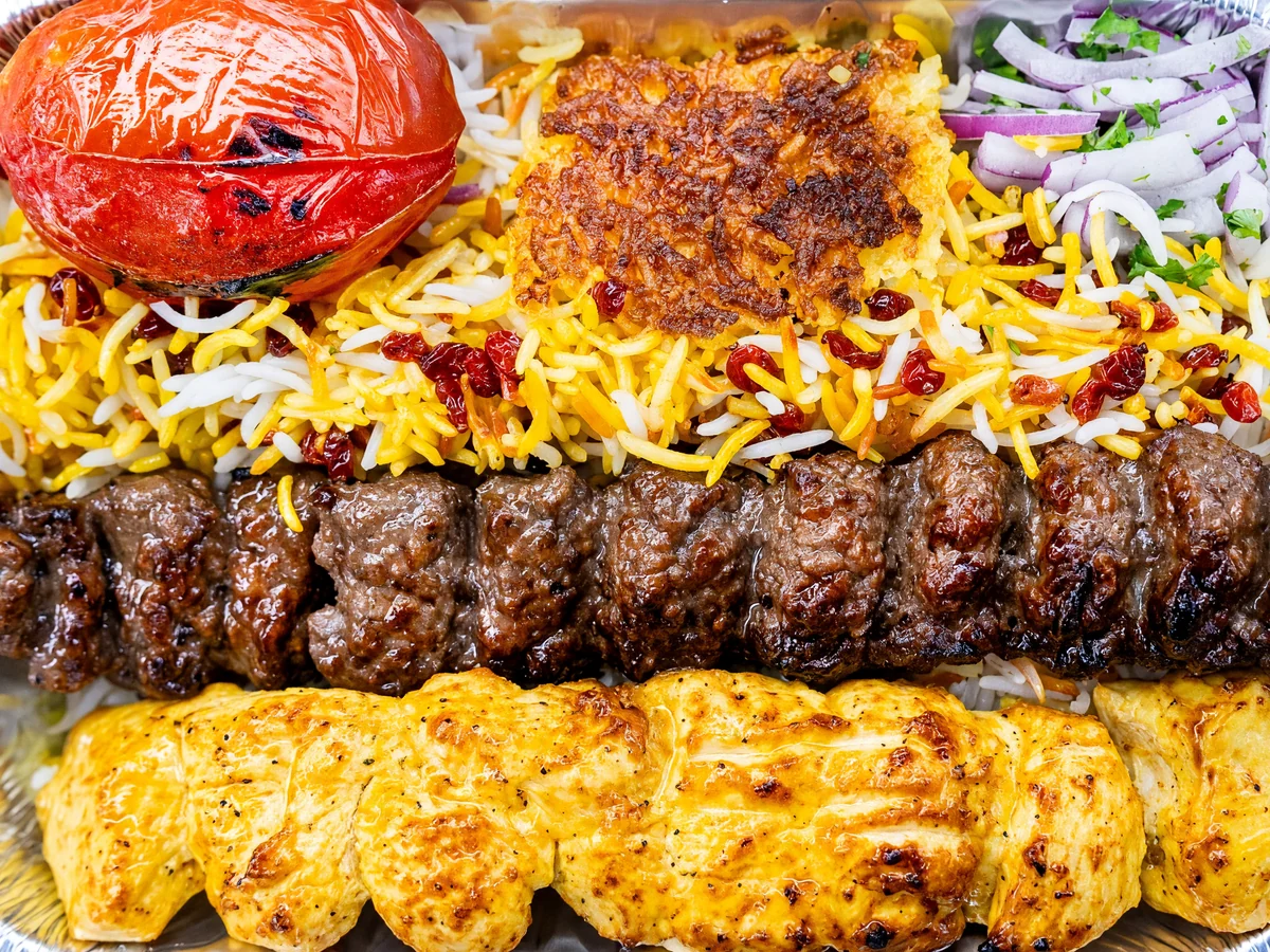 Vaziri: one beef koobideh skewer and one saffron chicken skewer with saffron rice, tahdig and a grilled tomato at AFRA Grill, Saskatoon